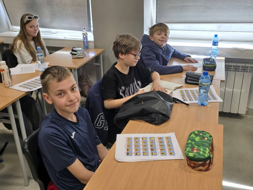 Zdjęcie przedstawia grupę młodzieży podczas zajęć w klasie