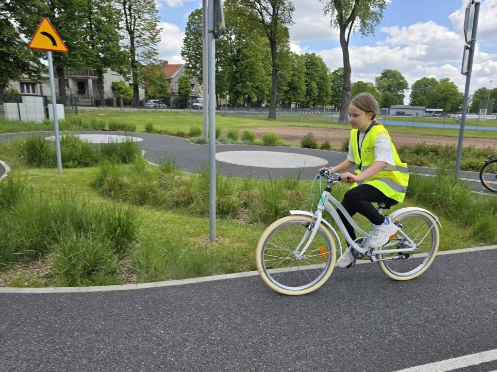 Zdjęcie przedstawia grupę młodzieży podczas zajęć w miasteczku ruchu drogowego