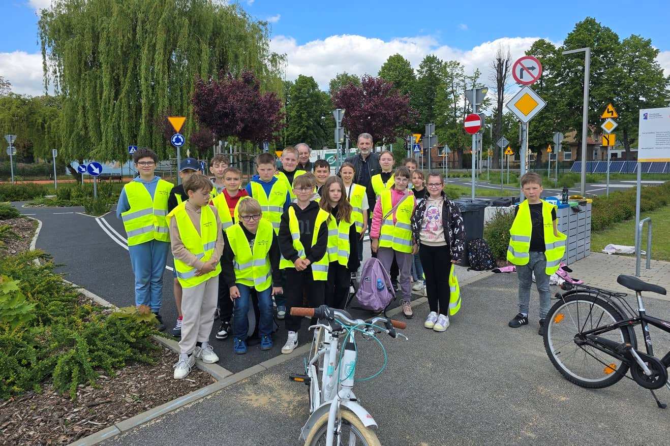 Zdjęcie przedstawia grupę młodzieży podczas zajęć w miasteczku ruchu drogowego