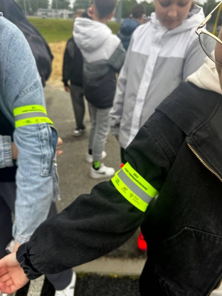 Zdjęcie przedstawia grupę młodzieży podczas zajęć w miasteczku ruchu drogowego