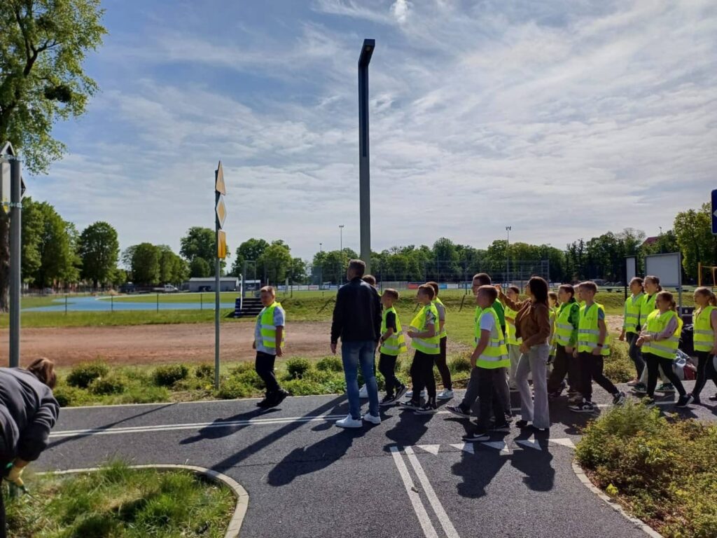 Zdjęcie przedstawia grupę młodzieży podczas zajęć w miasteczku ruchu drogowego