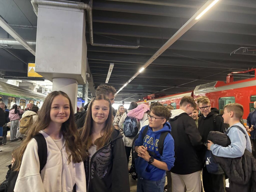 Na zdjęciu grupa młodzieży na dworcu PKP
