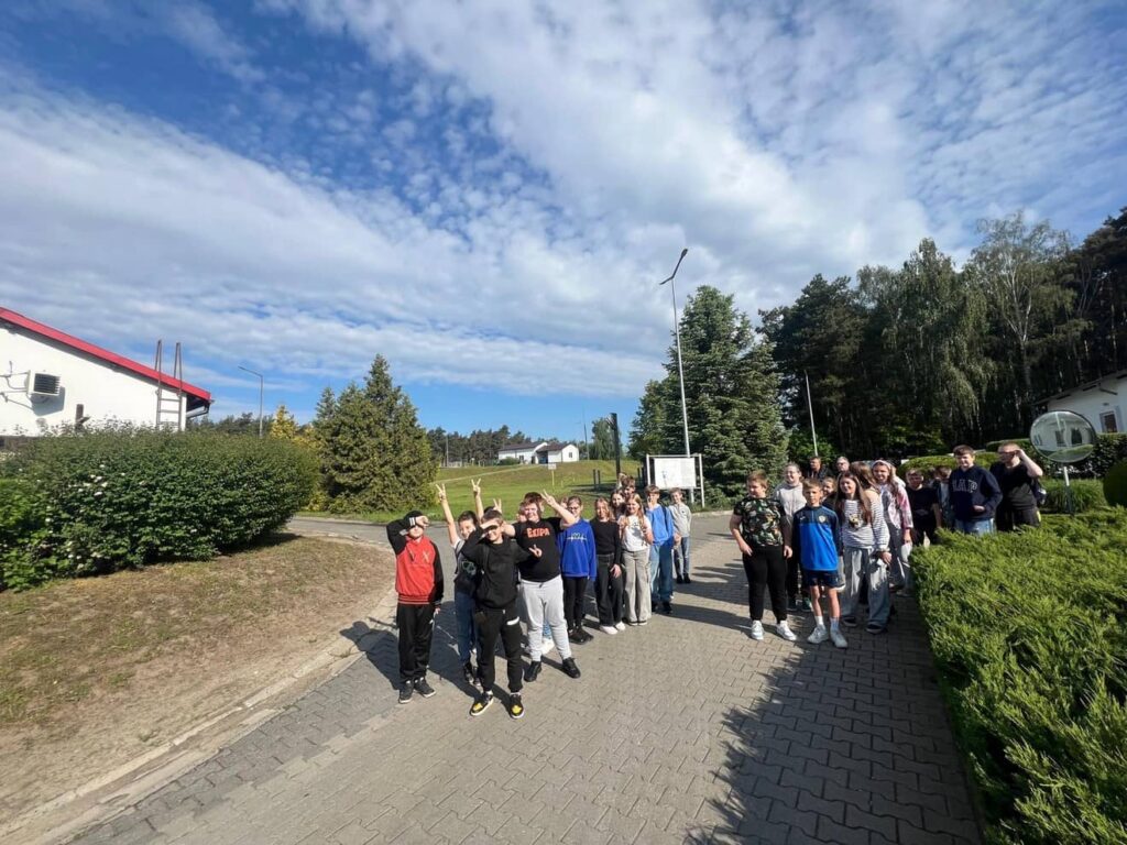 Zdjęcie przedstawia grupę młodzieży na terenie oczyszczalni ścieków w Pleszewie