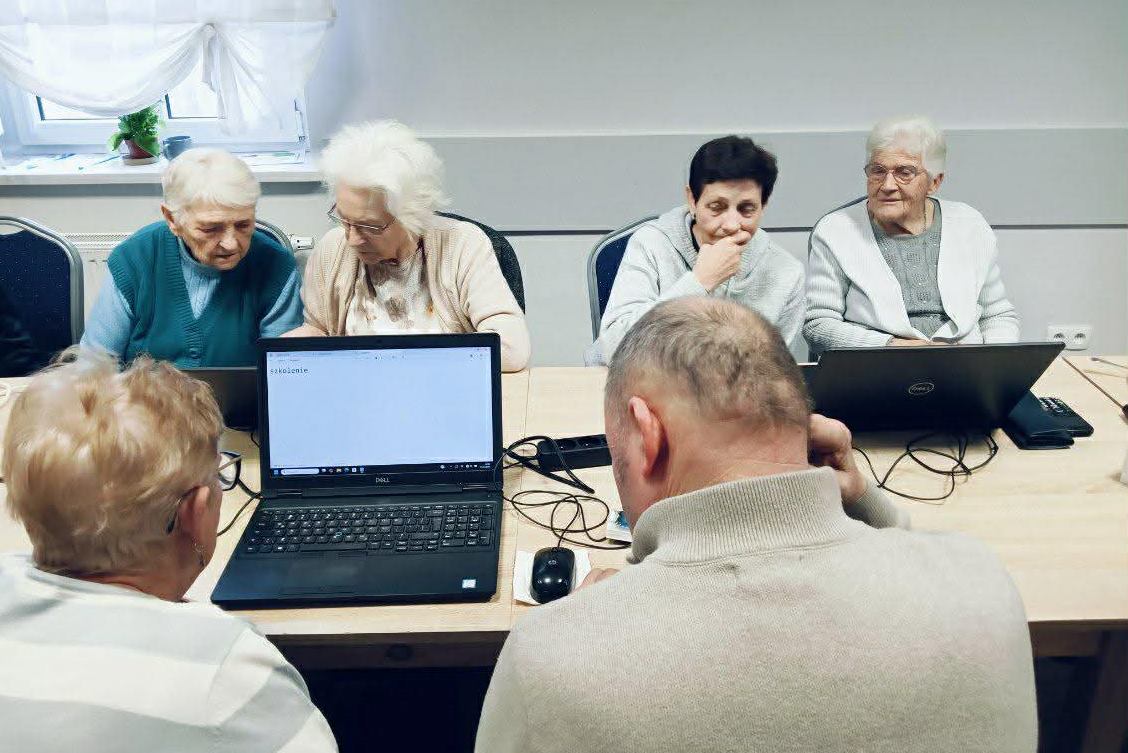 zdjęcie przedstawia osoby podczas szkolenia komputerowego